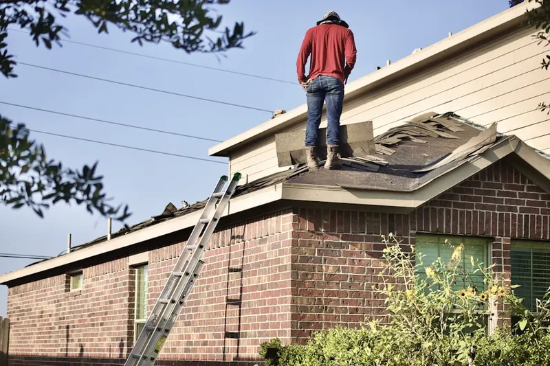 Professional roofer working on a residential roof in Long Green Manor